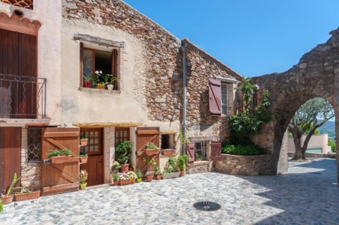 House facade and remains of the former town wall in the historic old town, Grimaud-Village, Var,