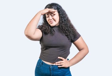 Tired and exhausted girl holding her forehead. Worried young woman holding his forehead. Exhausted
