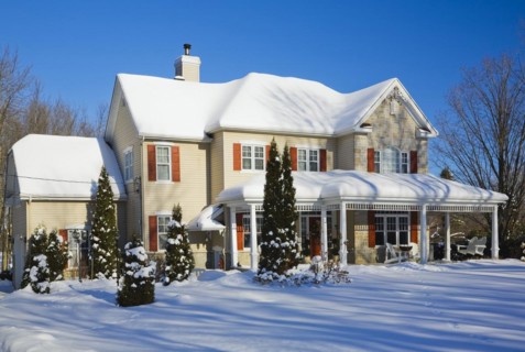 Two story beige vinyl siding with brownish red nuanced brick veneer and orange trim home in winter,