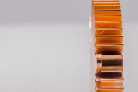 Closeup of copper computer heat sink fins on white background