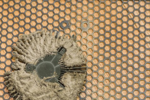 Central processing unit (CPU) with remnants of dried thermal paste on a patterned background, in