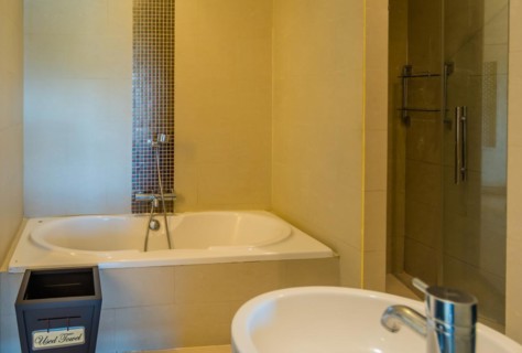 Modern bathroom with a clean bathtub, wall tiles, and a towel, in Chiang Mai, Thailand, Asia