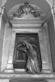 Sculpture of an old woman at a door with an hourglass, Monumental Cemetery, Cimitero monumentale di