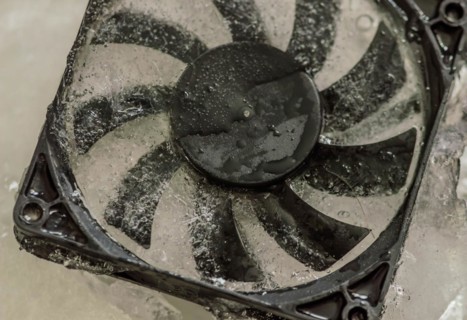 Closeup of computer case fan frozen in block of ice. Concept keep your computer cool