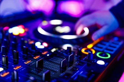 Hand of a DJ on a mixing desk, also called DJ controller or DJ console, at a party, Cologne, North