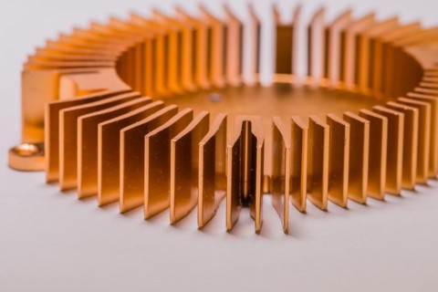 Closeup of round copper computer heat sink fins on white background