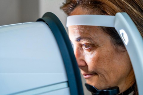 Close-up photo with side view of a mature woman receiving treatment in an innovative machine during