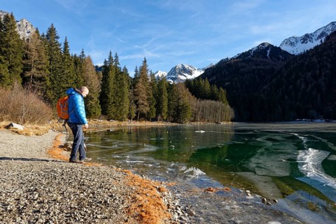 Hikers in winter on an icy lake, Lake Antholz in the Antholz Valley, Val Pusteria, South Tyrol,