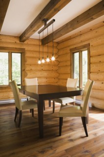 Brown wooden table and white cotton cloth upholstered high back chairs in dining room inside