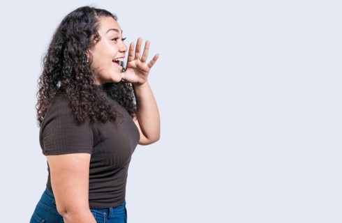 Happy girl announcing something isolated. Beautiful woman screaming and announcing an advertising