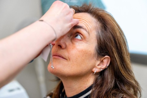 Ophthalmologist applies drops to dilate the pupil to a mature woman before a glaucoma test on the