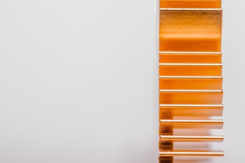 Closeup of copper computer heat sink fins on white background