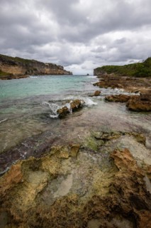 Rocky coast, long bay by the sea at sunset. Dangerous view of the Caribbean Sea. Tropical climate