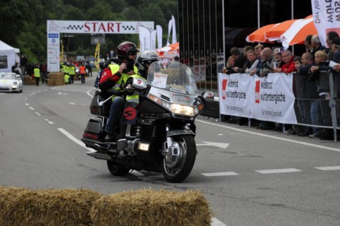 Police motorbike passing the starting line of an event, audience in the background, SOLITUDE