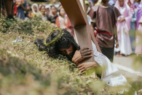 Christian devotees takes part in a perform to re-enactment of the crucifixion of Jesus Christ