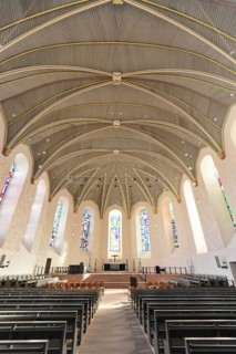 Speyer Cathedral, Empty rows of seats in a church with a view of the ceiling structure and stained