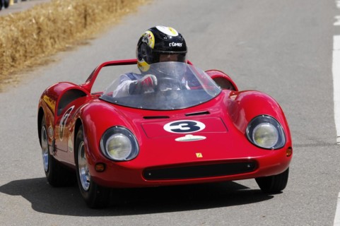 Intensely focussed driver in a bright red soapbox at high speed, SOLITUDE REVIVAL 2011, Stuttgart,
