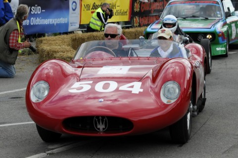 A red vintage sports car with a driver in a helmet at a race, SOLITUDE REVIVAL 2011, Stuttgart,