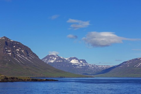 Rugged mountains and steep sea cliffs along the fjord Seyoisfjoerour, Seydisfjoerdur in summer,