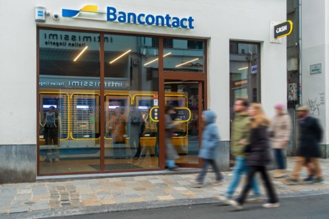 Shoppers walking past indoor ATM cash dispenser of bank neutral Bancontact CASH point in shopping