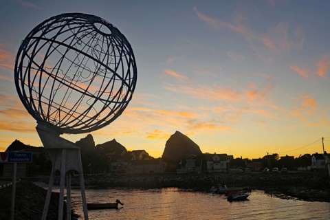 Large globe and small harbour in the evening light, Lovunden, Helgeland coast, Traena, Norway,