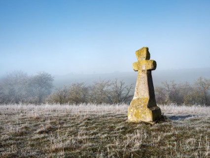 Medieval stone cross in hoarfrost and fog in winter, murder cross, atonement cross, Freyburg