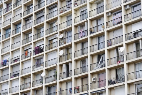 Marseille, Monotonous facade of a large apartment block with many balconies and washing lines,
