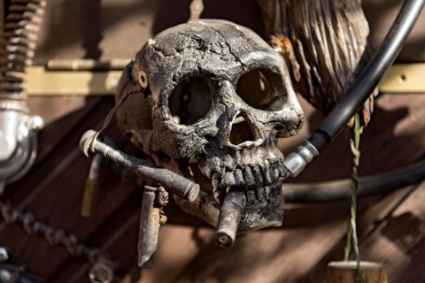 Old entrance door whimsically decorated, skull, engine parts, cartridge cases, tools, old town,