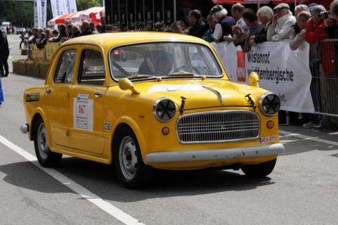 A small yellow car with starting number and accident damage at a classic car race, SOLITUDE REVIVAL