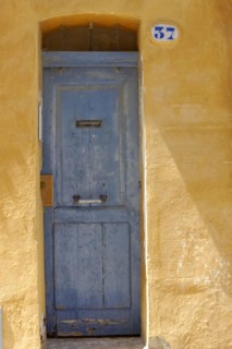 Marseille, Old faded blue door in a yellow plaster facade with the house number 37, Marseille,