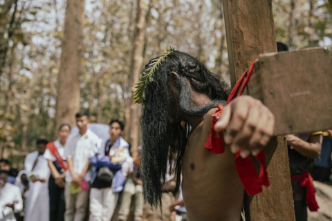 Christian devotees takes part in a perform to re-enactment of the crucifixion of Jesus Christ