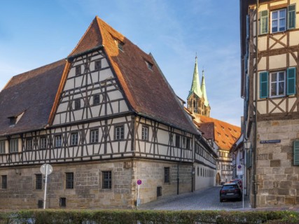 Alley with half-timbered houses and cobblestones, in the background the towers of Bamberg Cathedral