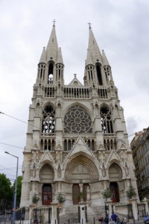 Church of Saint-Vincent-de-Paul, A Gothic church with twin towers rises in an urban setting,