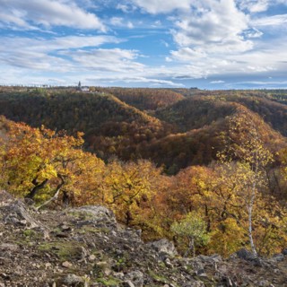 View over autumnal forests in the Selke valley, behind Falkenstein Castle, Harz Mountains,