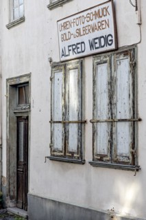 Closed shutters, abandoned photo shop with watch shop, jewellery, gold and silver, shop sign,
