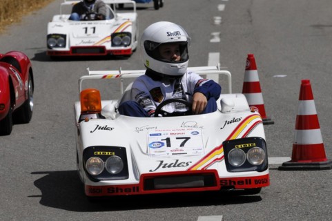 Racers in white miniature cars on a race track with spectator participation, SOLITUDE REVIVAL 2011,