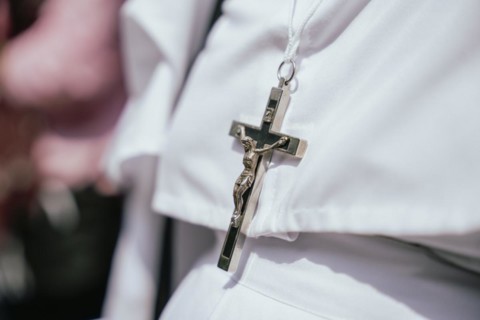 A nun wears a Cross as she recite prayers during a re-enactment of the crucifixion of Jesus Christ