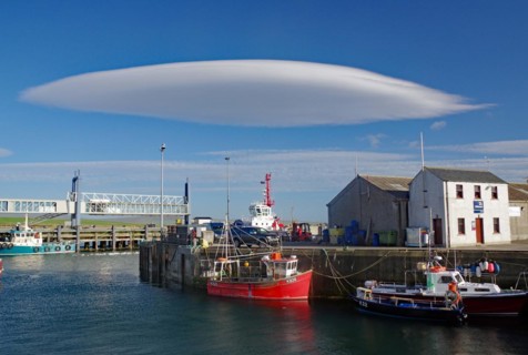 UFO cloud over a small harbour with fishing vessels, Stromness, Orkney Islands, Scotland, UK