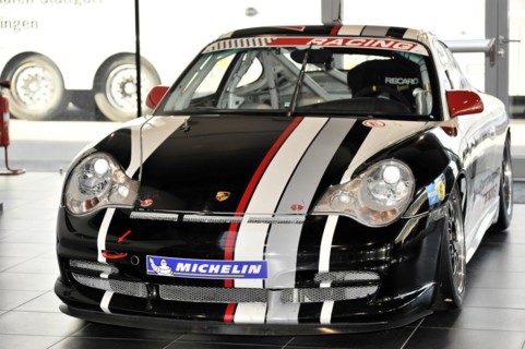 A black Porsche racing car with white and red stripes stands in the showroom, Schwaebisch Gmuend,
