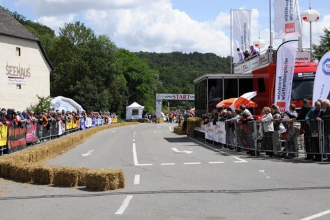 View of a race track with spectators and advertising banners on a cloudy day, SOLITUDE REVIVAL