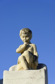 Church of Notre-Dame de la Garde, Marseille, statue of a pensive child in front of a clear blue