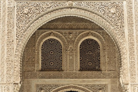 Artistic stone carvings, Alhambra, Granada, An intricately decorated window with arabesques in a