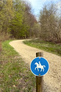 Sign for riders in front of designated signposted bridle path with soft sandy ground leading
