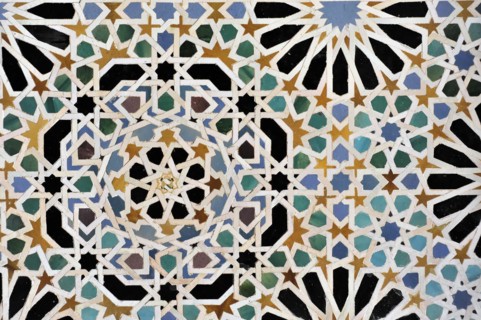 Artistic stone carvings, Alhambra, Granada, wall mosaic with complex geometric pattern in several