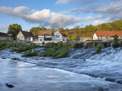 Half-timbered houses on the Weisse Elster river with weir, Wuenschendorf (Elster), Thuringia,