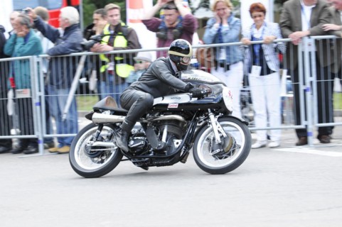 A motorbike racer in action, surrounded by spectators behind barriers, SOLITUDE REVIVAL 2011,