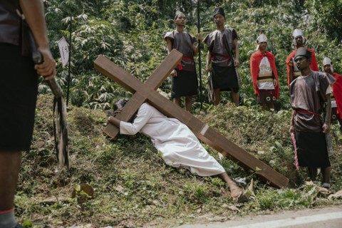 Christian devotees takes part in a perform to re-enactment of the crucifixion of Jesus Christ