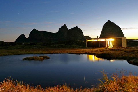 Striking rocks, small lake and tourist accommodation, Lovunden, Helgeland coast, Traena, Norway,
