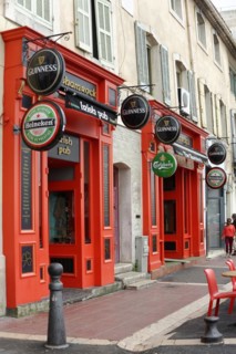 Marseille, Red facade of an Irish pub with outside tables on the pavement, Marseille, Departement