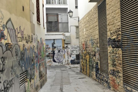 Jaen, Destroyed graffiti and murals covered with tags and messages on an urban street, Jaen,